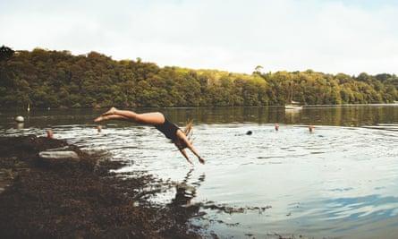 Woman diving into river at Thera-Sea retreat in Cornwall